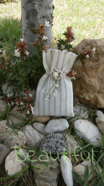 Μπομπονιέρα Γάμου, Πουγκί ριγέ εκρού με κορδόνι και λουλουδάκι χειροποίητο.